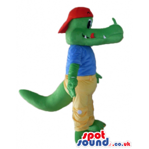 Crocodile wearing a red cap, a blue t-shirt and yellow trousers