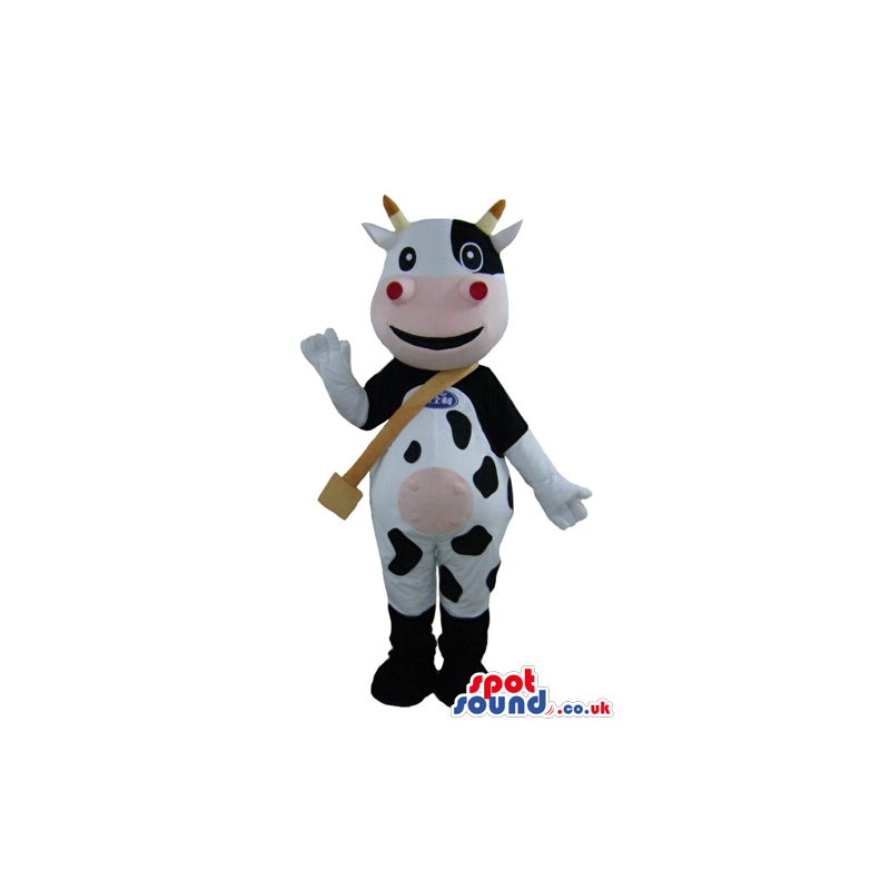 Smiling black and white cow with yellow horns, a pink mouth and